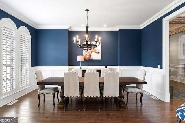 dining area featuring a notable chandelier, ornamental molding, and dark hardwood / wood-style floors