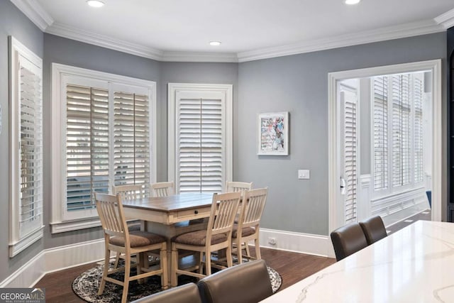 dining room with ornamental molding and dark hardwood / wood-style flooring