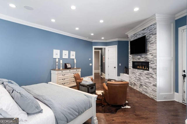 bedroom with hardwood / wood-style floors, crown molding, and a fireplace