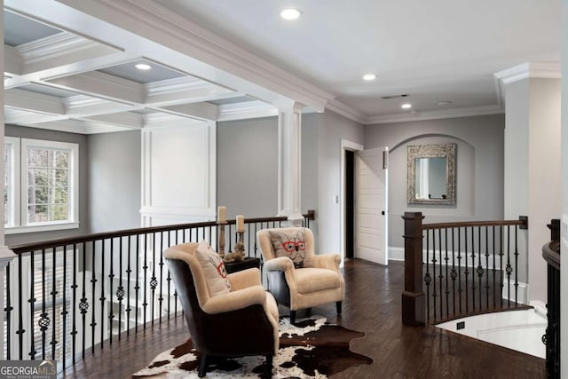 interior space with decorative columns, coffered ceiling, ornamental molding, dark hardwood / wood-style flooring, and beamed ceiling