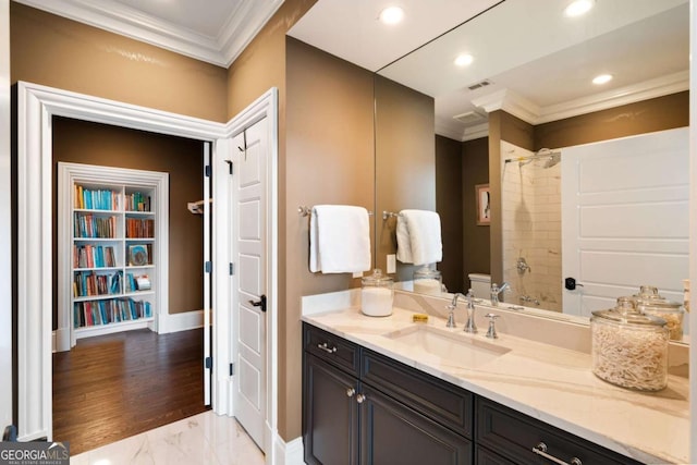 bathroom featuring vanity, ornamental molding, and toilet