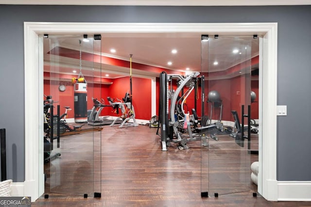 workout area featuring hardwood / wood-style flooring and ornamental molding