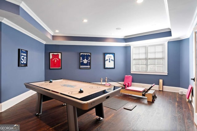 recreation room with a raised ceiling, ornamental molding, and dark hardwood / wood-style floors