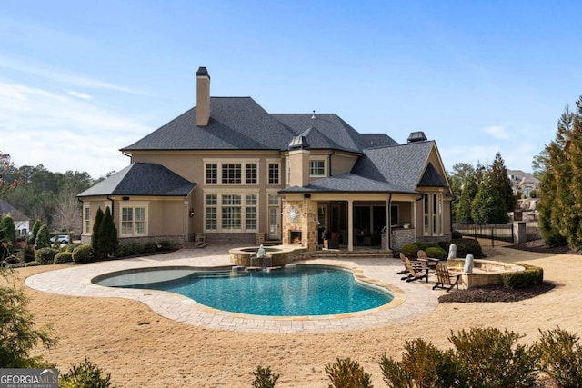 back of house featuring a pool with hot tub and a patio area