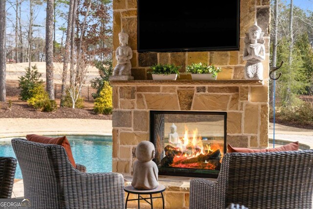 exterior details with a pool and an outdoor stone fireplace