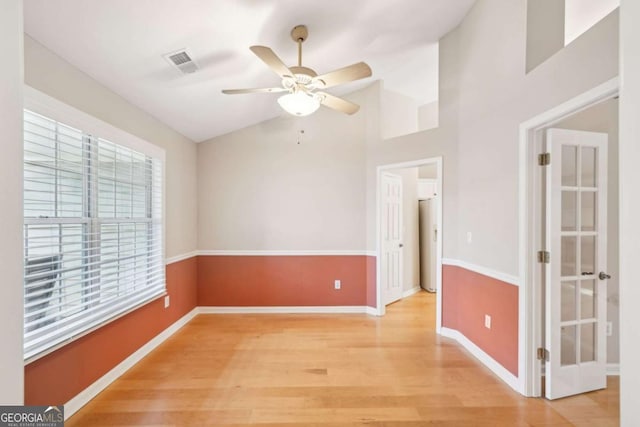 empty room featuring hardwood / wood-style floors, vaulted ceiling, and ceiling fan