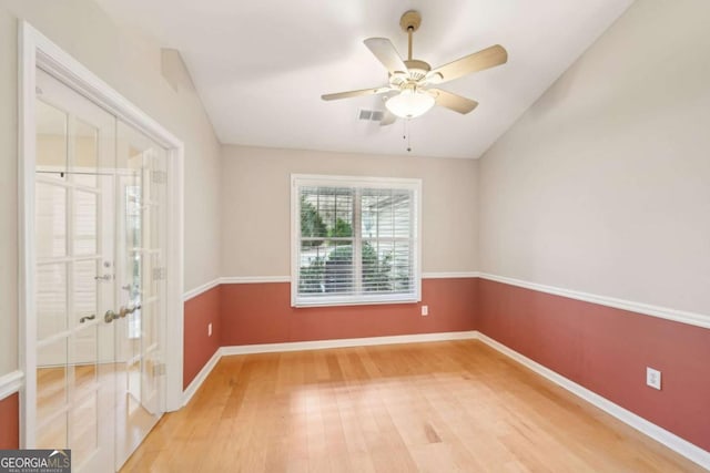 empty room with hardwood / wood-style floors, ceiling fan, and french doors