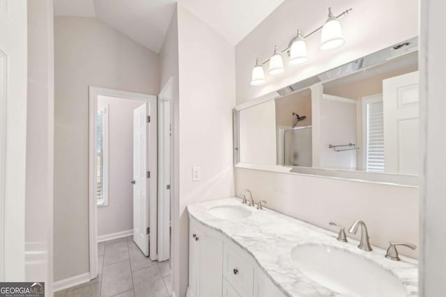 bathroom with a shower with door, vaulted ceiling, tile patterned flooring, and vanity