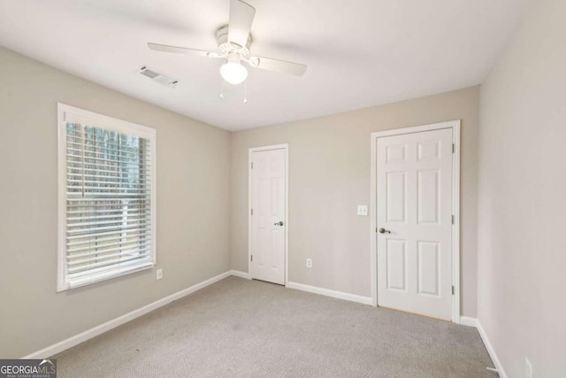 unfurnished bedroom with ceiling fan and light colored carpet