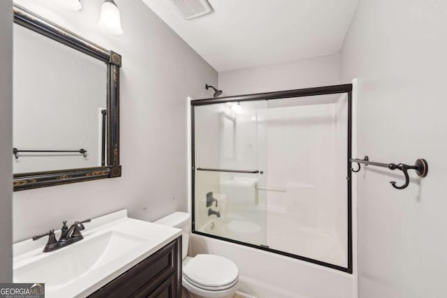 full bathroom with vanity, combined bath / shower with glass door, and toilet