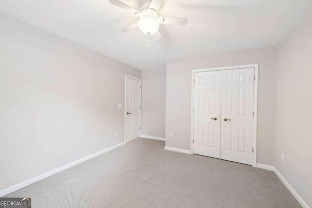 unfurnished bedroom featuring light carpet, a closet, and ceiling fan