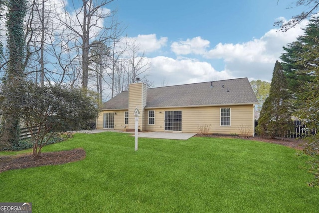 rear view of house with a patio and a lawn