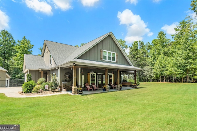 rear view of house featuring covered porch and a lawn