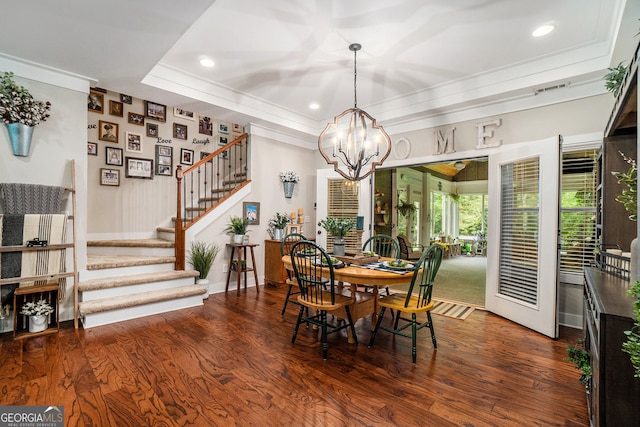 dining room with a raised ceiling, crown molding, dark hardwood / wood-style floors, and an inviting chandelier