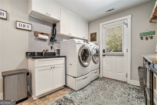 washroom with sink, washer and clothes dryer, and cabinets