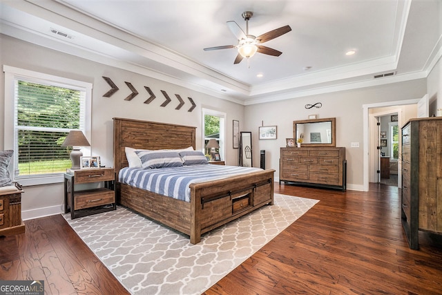 bedroom with wood-type flooring, ornamental molding, a raised ceiling, and ceiling fan