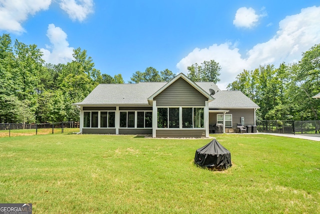 rear view of house with a sunroom and a lawn