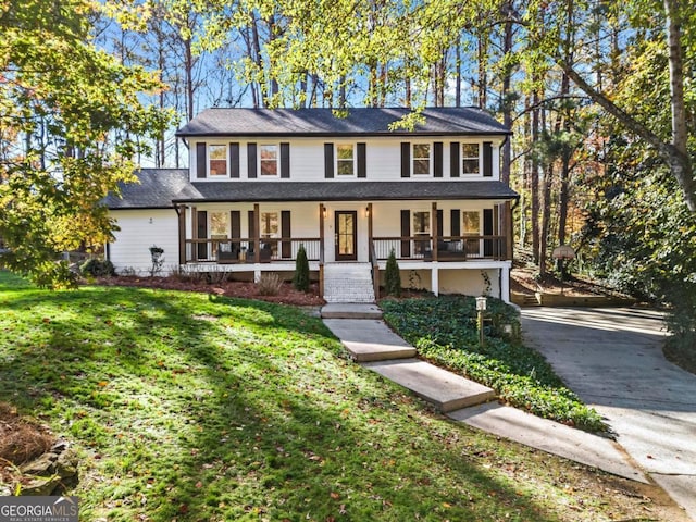 view of front of property featuring a garage, a front yard, and a porch