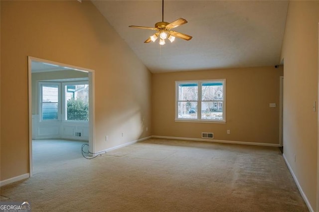 carpeted empty room featuring plenty of natural light, high vaulted ceiling, and ceiling fan