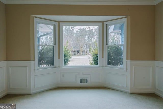 entryway featuring ornamental molding and light colored carpet