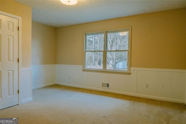 carpeted empty room featuring a textured ceiling