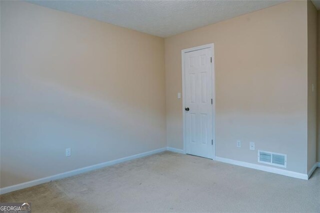 carpeted spare room featuring a textured ceiling