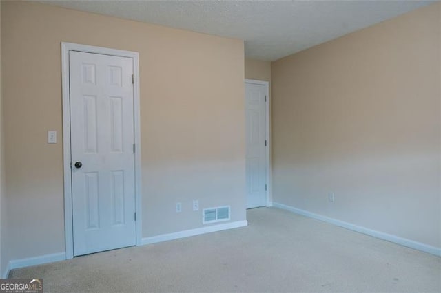 carpeted spare room with a textured ceiling