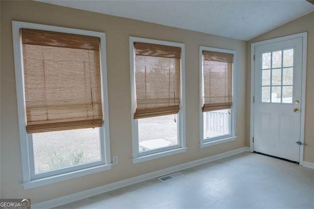 doorway featuring plenty of natural light and vaulted ceiling