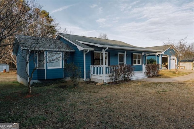 single story home featuring a garage, a front yard, and covered porch