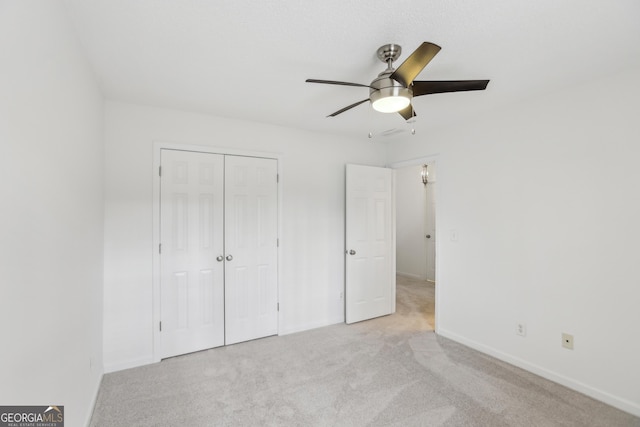 unfurnished bedroom with light carpet, ceiling fan, and a closet