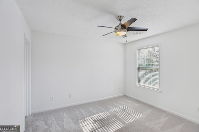 carpeted spare room with ceiling fan and a textured ceiling