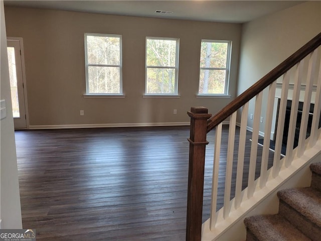 stairs featuring wood finished floors, visible vents, and baseboards