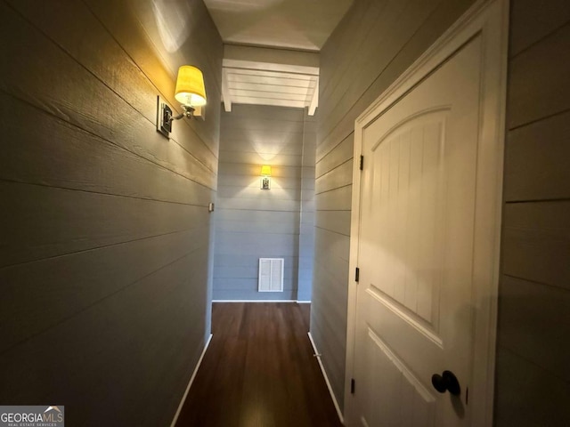 hallway featuring wood walls