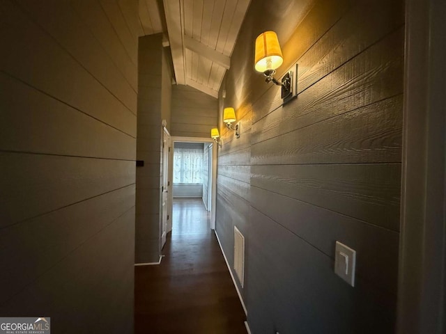 hallway featuring vaulted ceiling with beams, wood ceiling, and wood walls