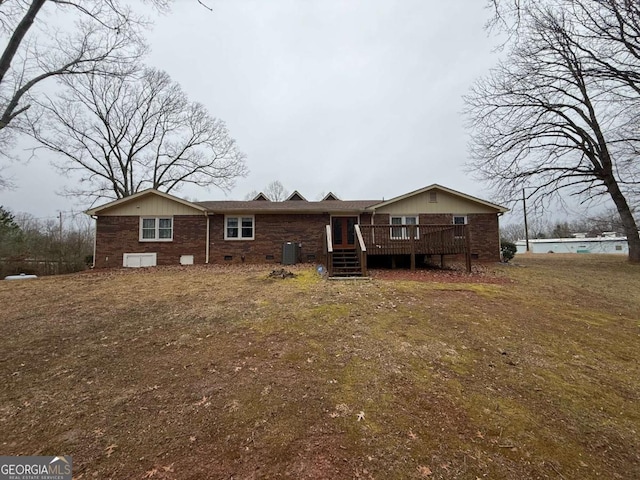 rear view of property with a wooden deck, a yard, and cooling unit