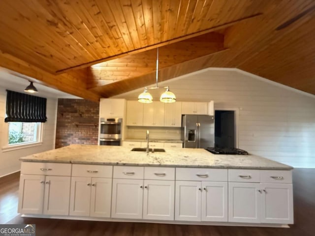 kitchen featuring appliances with stainless steel finishes, decorative light fixtures, sink, white cabinets, and light stone countertops