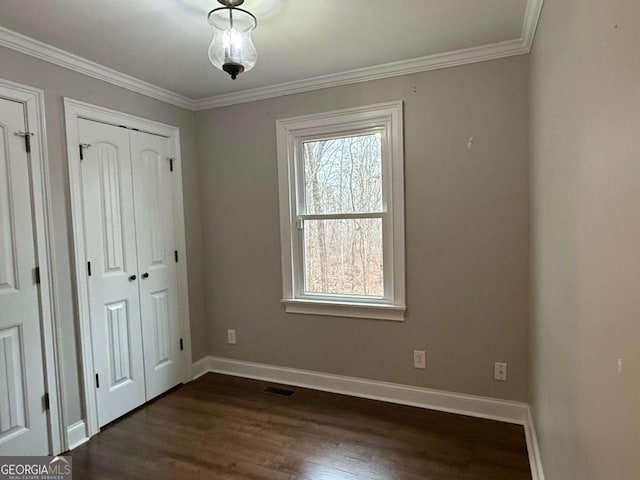 unfurnished bedroom with ornamental molding and dark hardwood / wood-style flooring