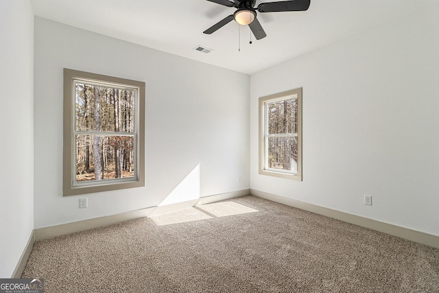 carpeted spare room with ceiling fan