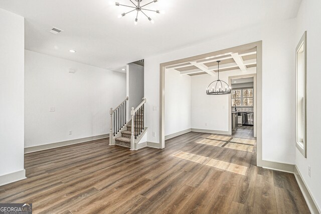 spare room with beam ceiling, coffered ceiling, a notable chandelier, and dark hardwood / wood-style flooring