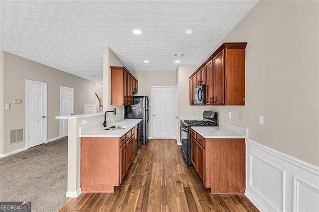 kitchen featuring dark hardwood / wood-style floors, sink, a textured ceiling, and black appliances