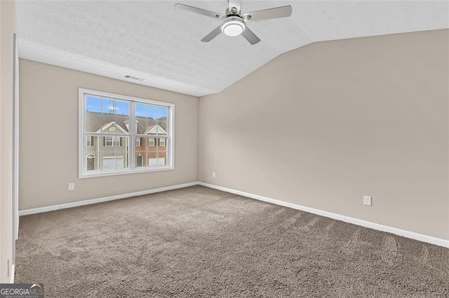 unfurnished room featuring ceiling fan, vaulted ceiling, carpet, and a textured ceiling