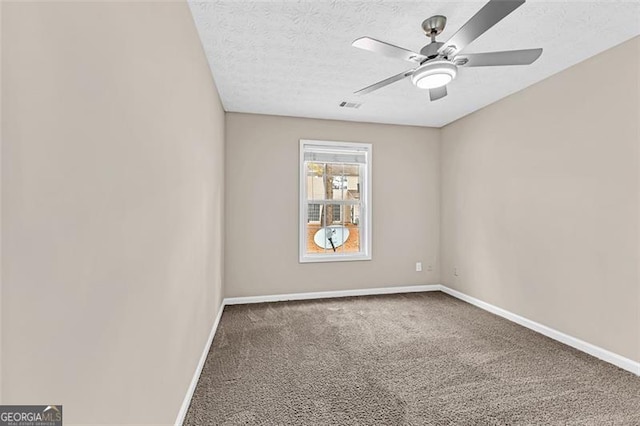 carpeted spare room with ceiling fan and a textured ceiling