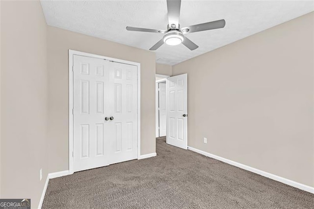 unfurnished bedroom featuring ceiling fan, dark carpet, and a closet