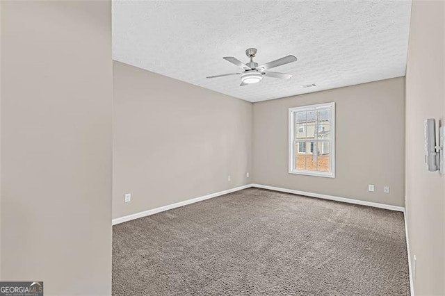 carpeted empty room with ceiling fan and a textured ceiling