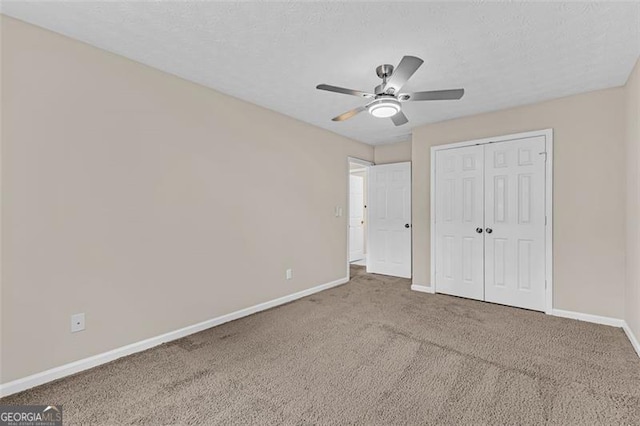 unfurnished bedroom featuring ceiling fan, carpet, a textured ceiling, and a closet