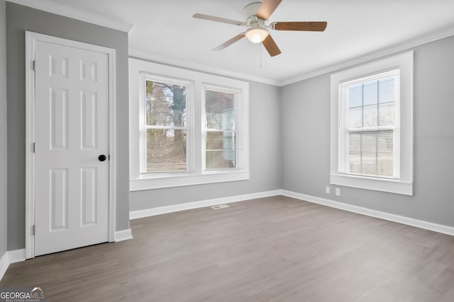 empty room featuring hardwood / wood-style floors, ceiling fan, and ornamental molding