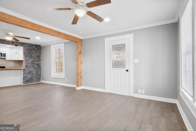 unfurnished living room with ceiling fan, ornamental molding, and hardwood / wood-style floors