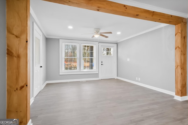 interior space with light wood-type flooring, ornamental molding, and ceiling fan