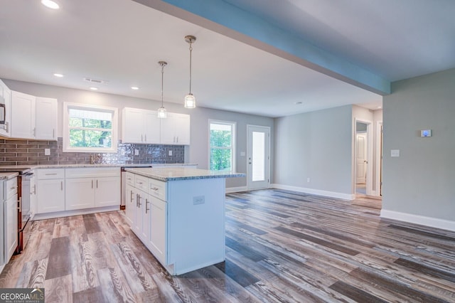 kitchen with white cabinetry, range with electric cooktop, and a kitchen island