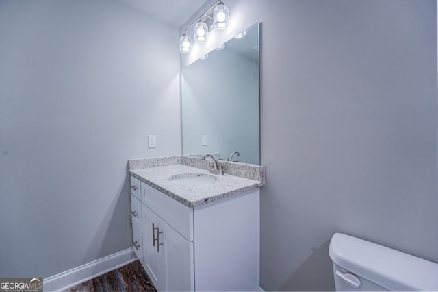 bathroom with vanity, wood-type flooring, and toilet